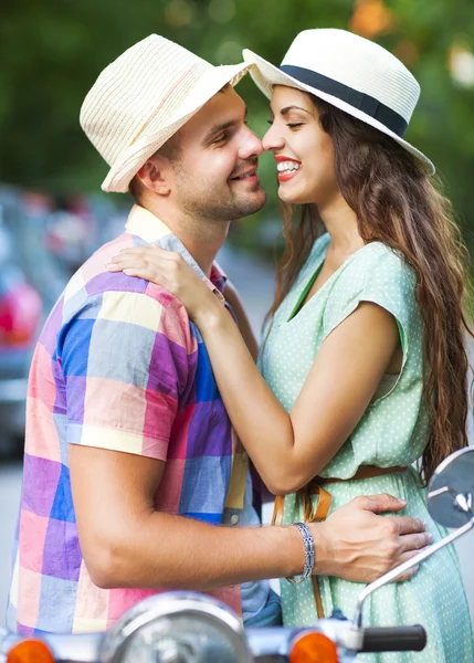 Happy young couple near the vintage scooter in the street — Stock Photo, Image