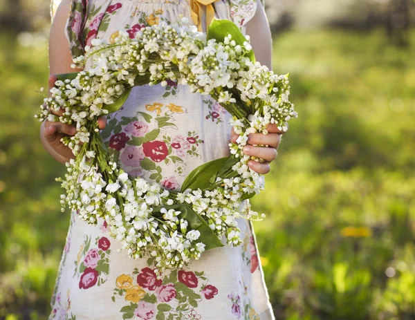 Little girl holding wreath from lily of the valley — Stock Photo, Image