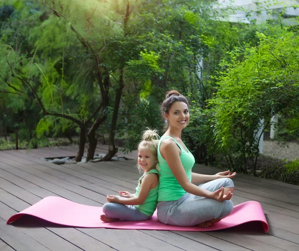 Madre e hija haciendo ejercicio practicando yoga al aire libre —  Fotos de Stock