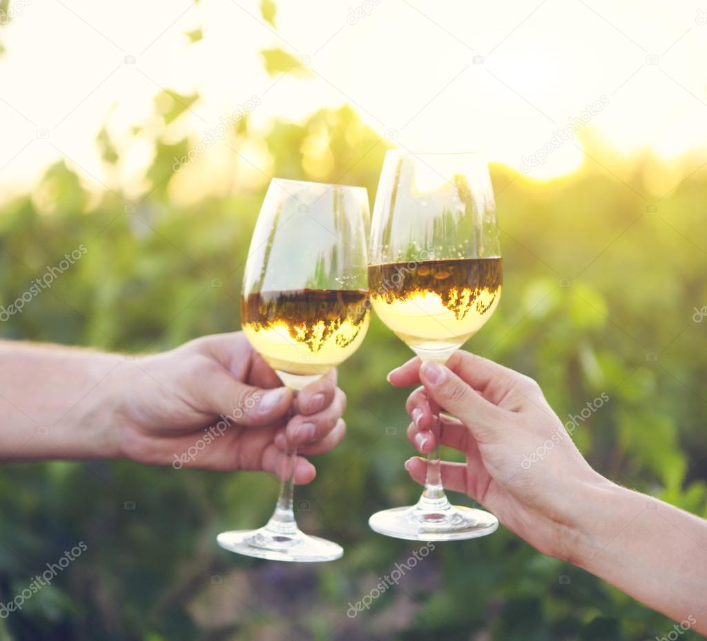 Young happy couple enjoying a glasses of white wine 