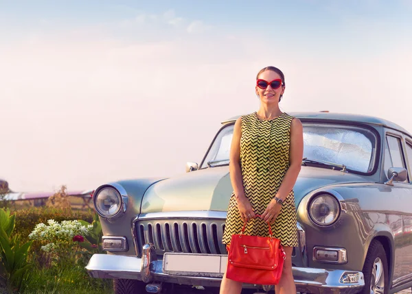 Brunette woman standing near retro car — Stock Photo, Image