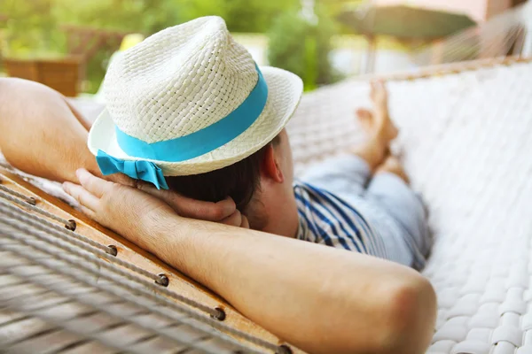 Man in hat in a hammock on a summer day — Stock Photo, Image