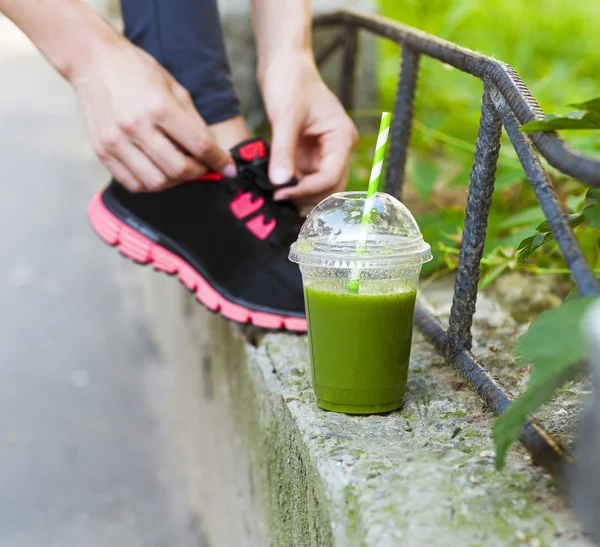 Verde tazza di frullato di disintossicazione e donna allacciatura scarpe da corsa prima w — Foto Stock