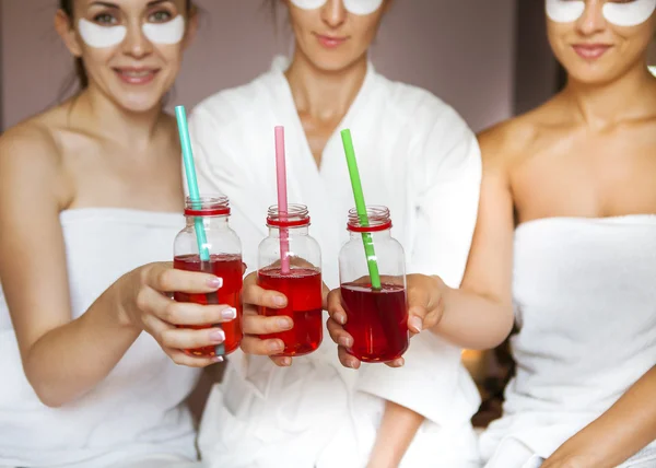 Junge glückliche Freundinnen trinken Saft im Wellnessbereich und haben Spaß — Stockfoto