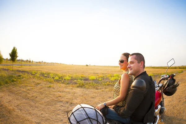 Biker couple on the country road against the sky — Stock Photo, Image