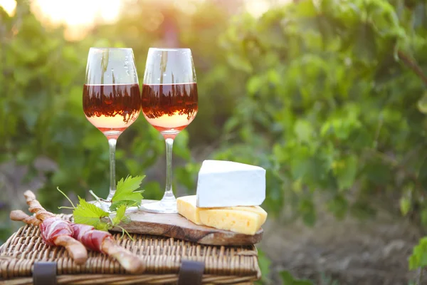 Dos vasos de vino de rosas con pan, carne, uva y queso —  Fotos de Stock
