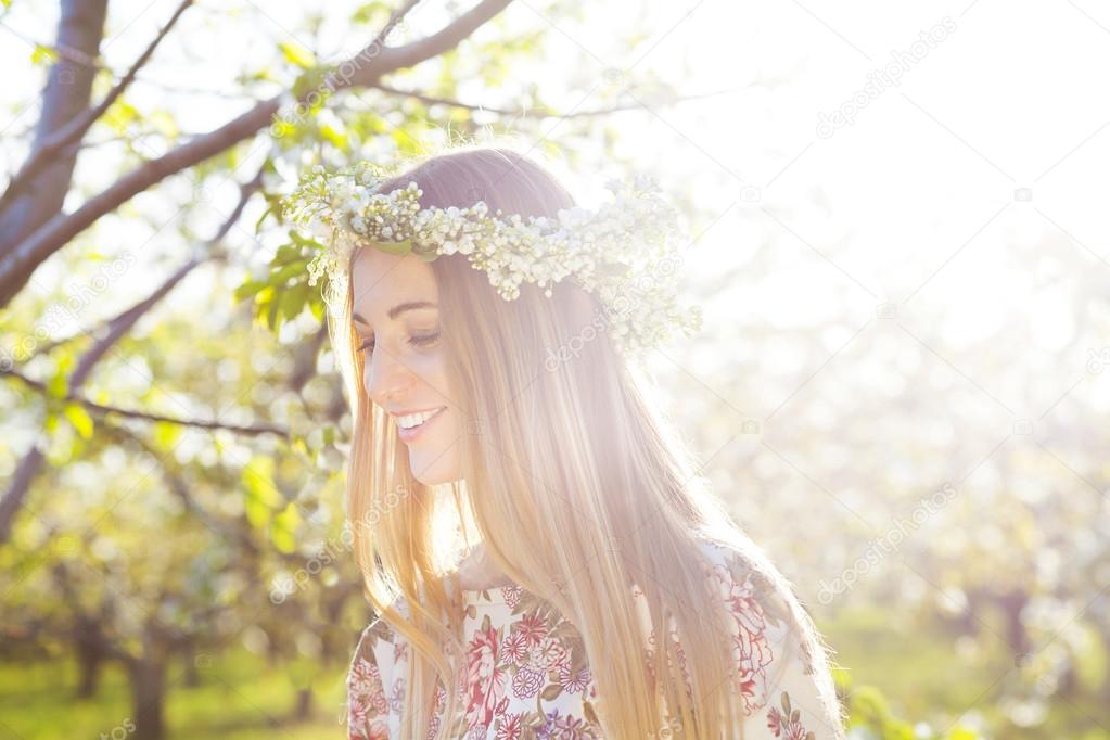 Beautiful romantic woman with long blond hair in a wreath of lil