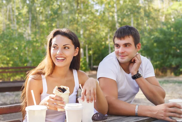 Man en vrouw of jonge paar drinken koffie in stadspark — Stockfoto