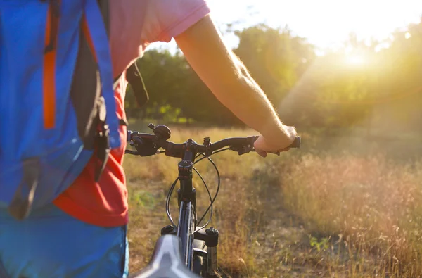 Young man with bicycle in the summer field. — Stock Photo, Image