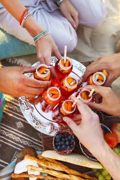 Gruppo di amici che organizzano drink al picnic estivo — Foto Stock