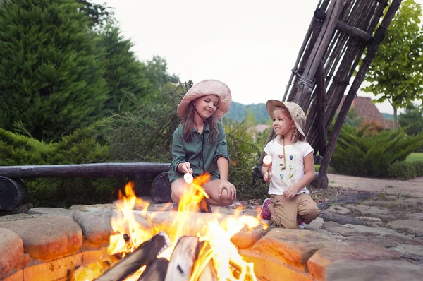 Két boldog nővérek, pörkölés marshmallows — Stock Fotó