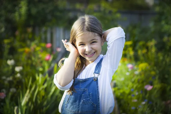 Portret van gelukkig lachend meisje in zonnige tuin — Stockfoto