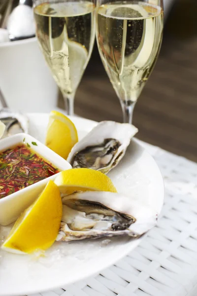 Fresh oysters shell with lemon and glasses of champagne. Top of — Stock Photo, Image