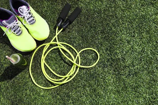 Взуття для бігу, стрибок мотузки і пляшка з зеленим соком — стокове фото