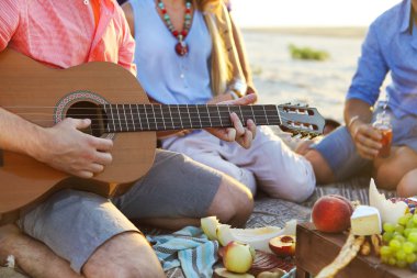 Daire içinde plajda kum üzerinde oturan arkadaşlar. Bir adamdır: p