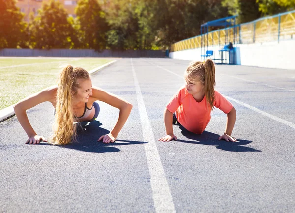 母亲和小女儿在体育馆锻炼 — 图库照片