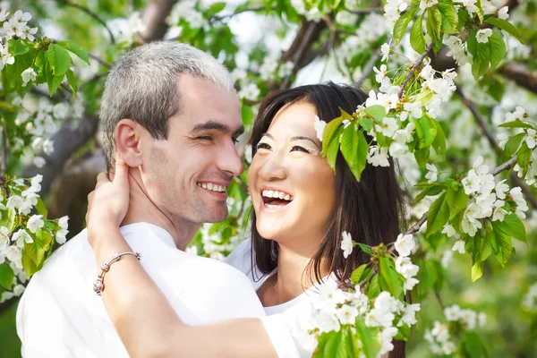 Happy leende par i kärlek i blommor trädgård — Stockfoto