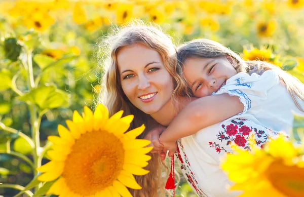 Mutlu anne ve küçük kızı ayçiçeği tarlasında — Stok fotoğraf