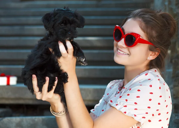 Young brunette woman hugging her lap dog puppy — Stock Photo, Image
