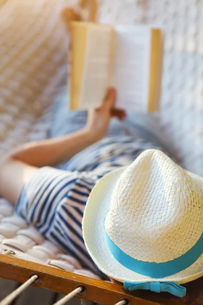 Uomo in cappello su un'amaca con libro in un giorno d'estate — Foto Stock