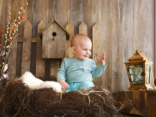 Portret van een schattige babymeisje in de buurt van de houten achtergrond — Stockfoto