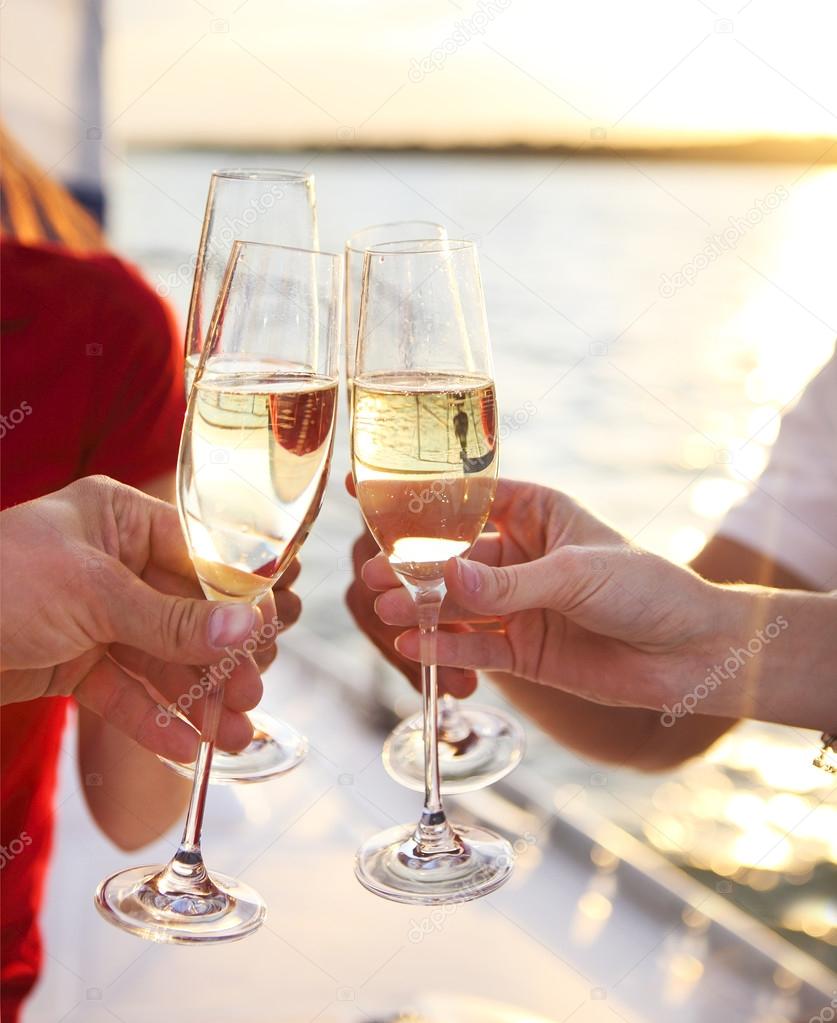 Happy friends with glasses of champagne on yacht. Vacation, trav