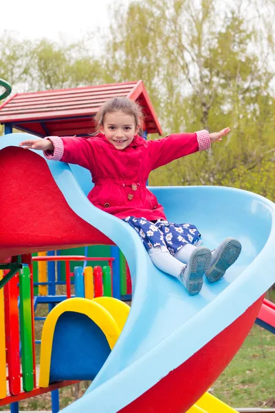 Active playing little girl in red clothes and blue dress with fl — Stock Photo, Image