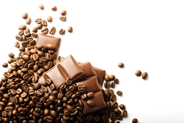 Granos de café tostados y piezas de chocolate sobre fondo blanco — Foto de Stock