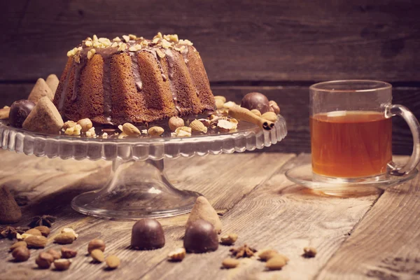 Gâteau, bonbons, noix et tasse sur un vieux fond en bois — Photo
