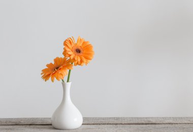 Eski ahşap masa üzerinde vazoda gerbera