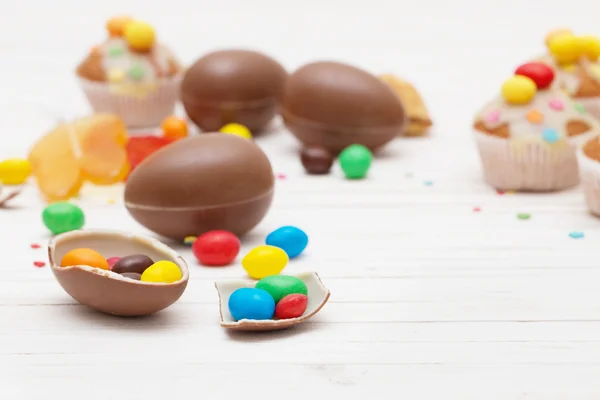 Čokoládová velikonoční vejce a košíček dřevěné pozadí — Stock fotografie