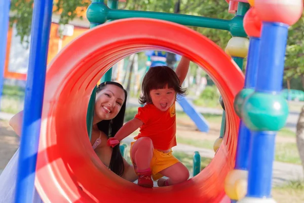 Familia feliz en el patio de recreo en verano — Foto de Stock