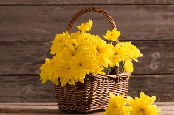 Flowers in basket on wooden background — Stock Photo, Image