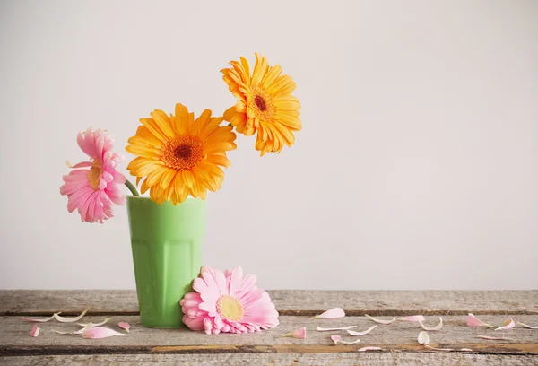 Gerbera en jarrón sobre mesa de madera vieja —  Fotos de Stock