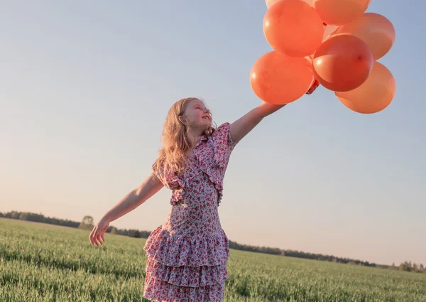 Glad tjej med orange ballonger utomhus — Stockfoto