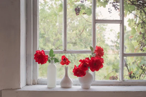 Rosas rojas en alféizar de la ventana — Foto de Stock