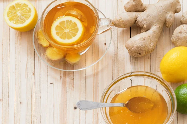 Tazza di tè allo zenzero con limone e miele su sfondo di legno — Foto Stock