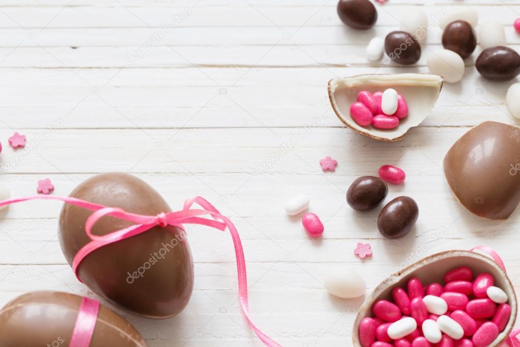 Chocolate and pink Easter eggs on white background