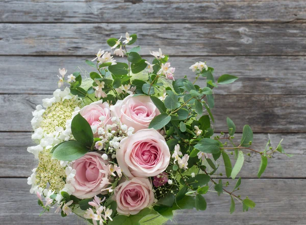 Ramo de rosas sobre mesa de madera — Foto de Stock