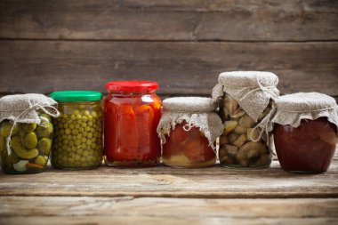 Ahşap arka plan üzerinde turşu sebzeli kavanoz