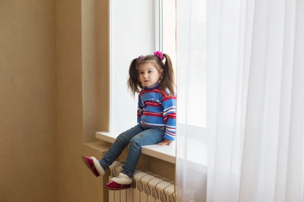 Pequena menina beleza na janela — Fotografia de Stock