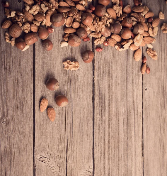 Gemischte Nüsse auf altem Holzgrund — Stockfoto