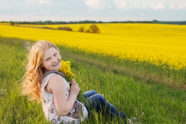 Cute funny girl on rape field — Stock Photo, Image