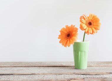 Eski ahşap masa üzerinde vazoda gerbera