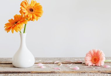 Eski ahşap masa üzerinde vazoda gerbera