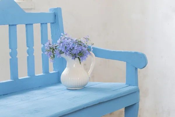 Still life with spring flowers on blue bench — Stock Photo, Image