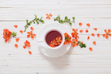 Çiçekli Beyaz ahşap zemin üzerinde kırmızı çay