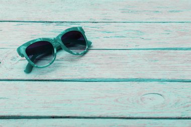 ahşap bir masa üzerinde güneş gözlüğü