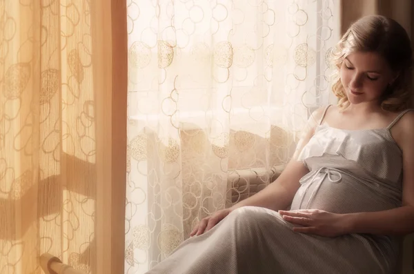Έγκυος γυναίκα κάθεται στο παράθυρο — Φωτογραφία Αρχείου