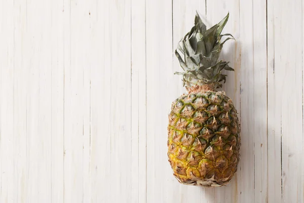 Pineapple on white wooden table — Stock Photo, Image